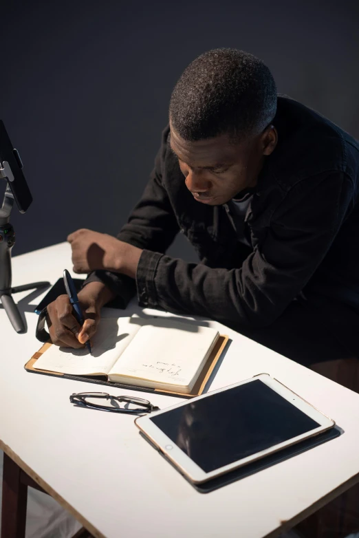 the person is writing while looking at the computer