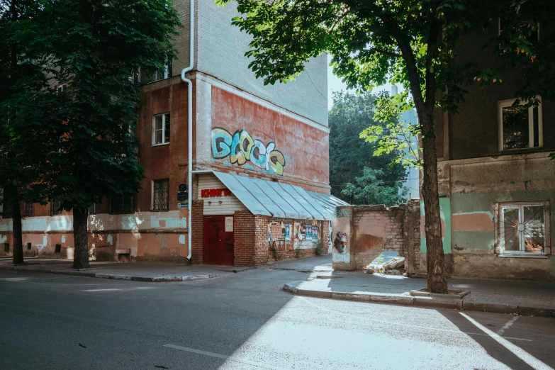 a brick building with graffiti on it is next to an empty street