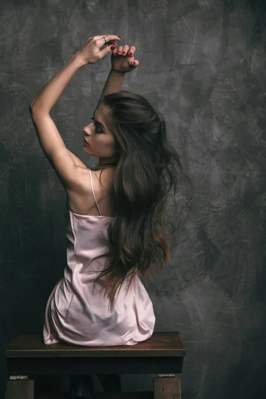 the woman sits on a wooden table and poses