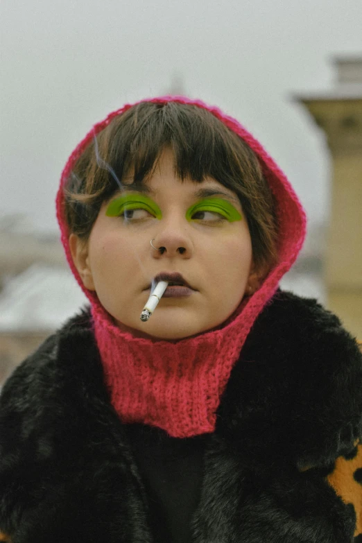 a young woman wearing a pink and black coat with a pipe