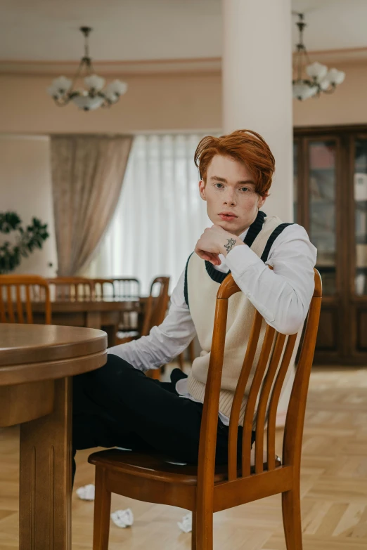 a man is sitting on a wooden chair