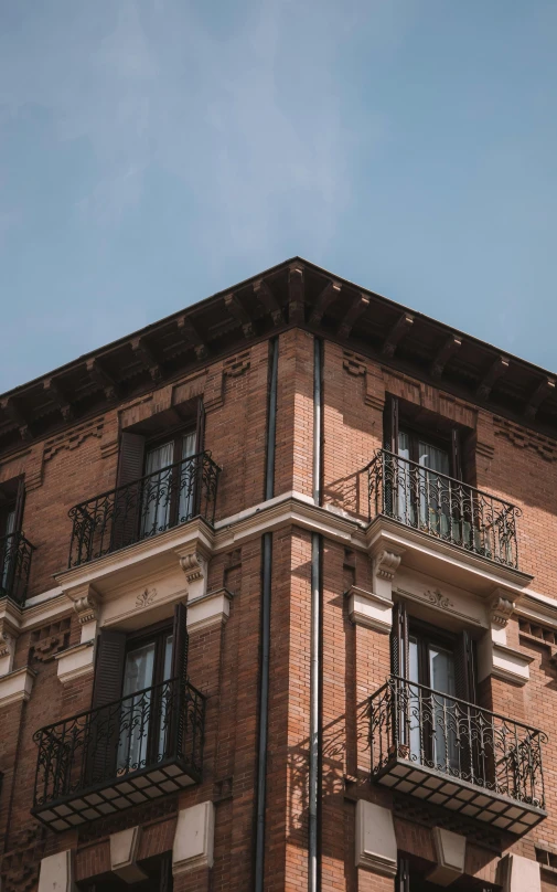 a tall brick building with balcony balconies and metal railings