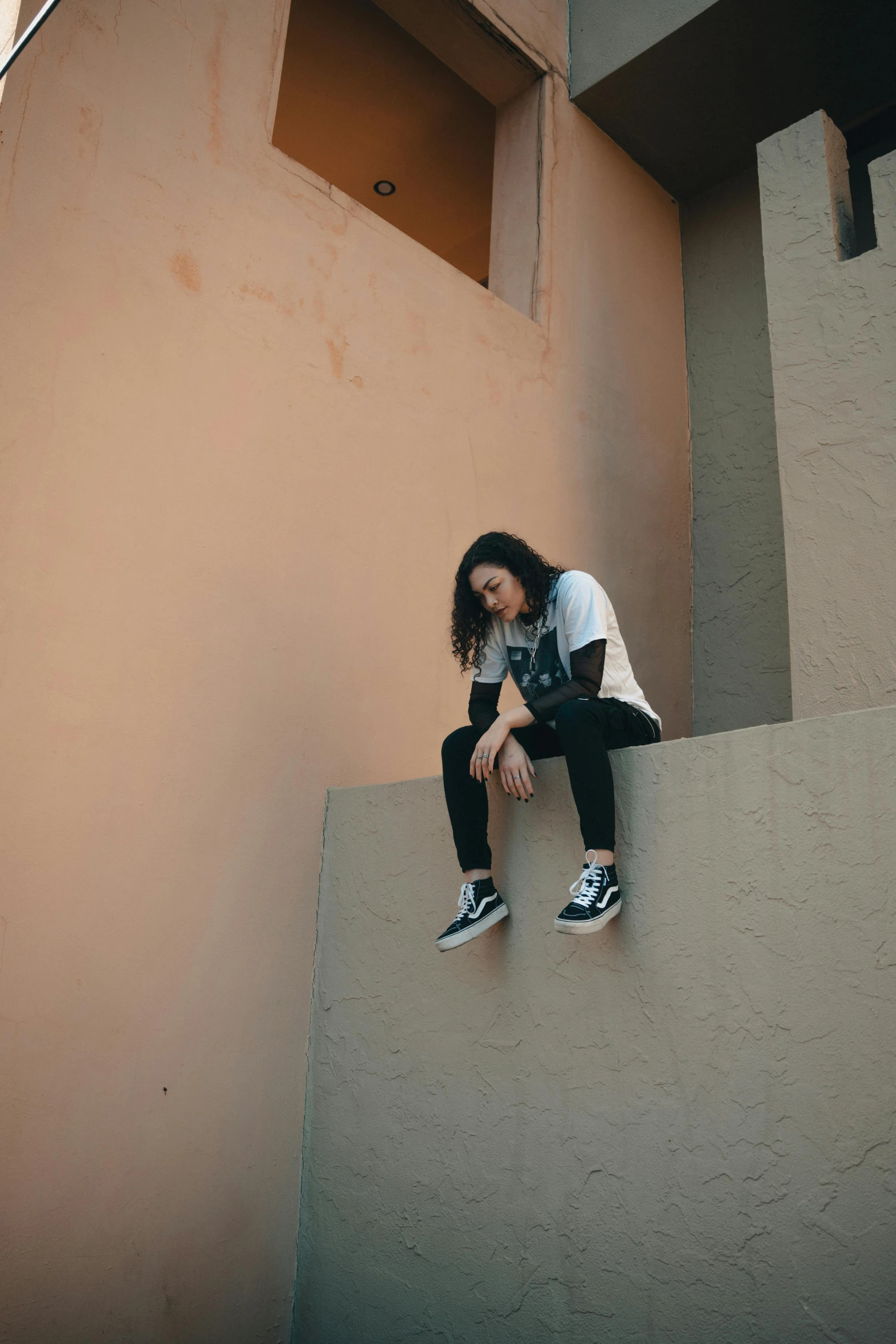 a young lady sits alone on some concrete stairs