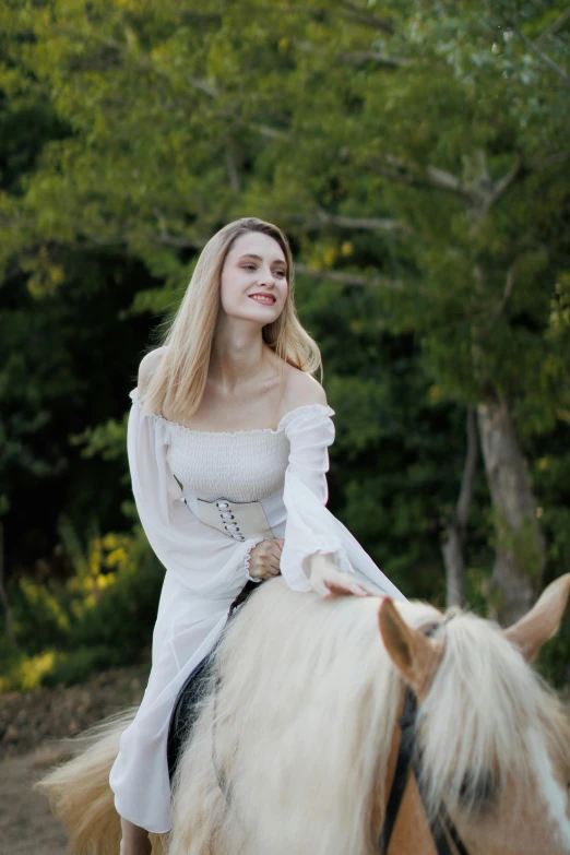 a woman riding a horse with blond hair