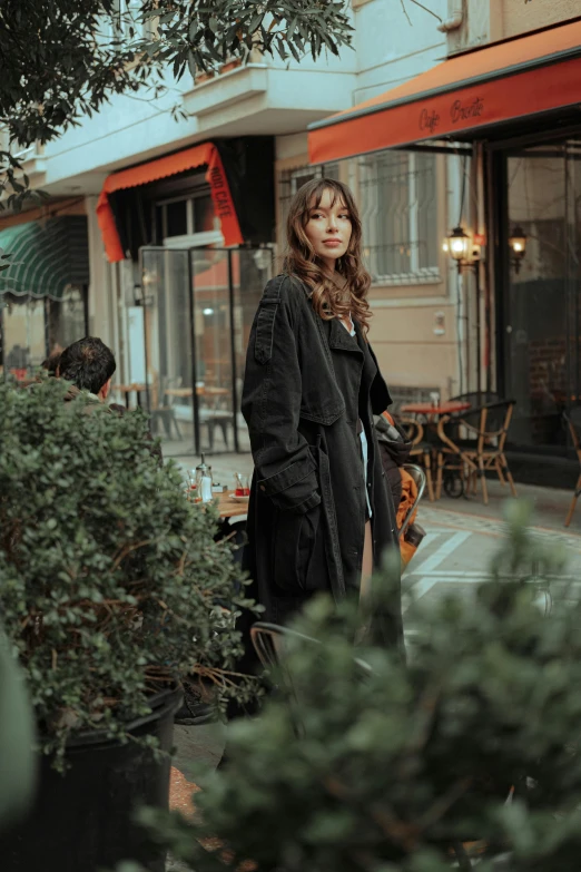 a woman stands outside in front of a restaurant