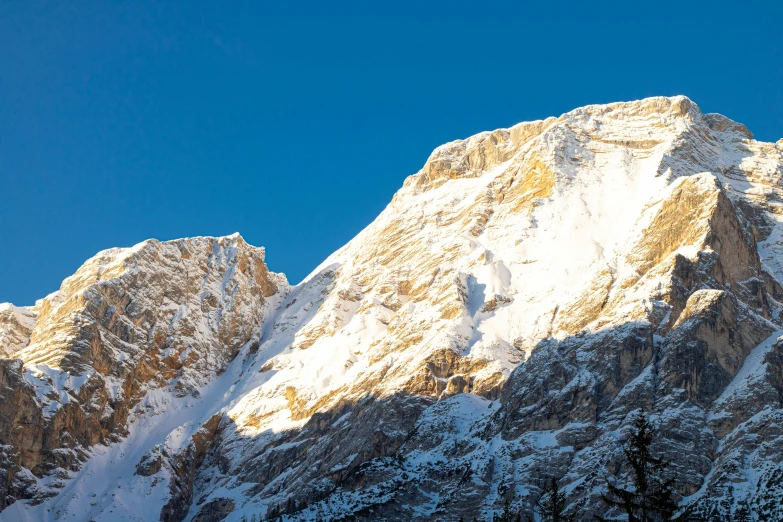 the sun shining on some snow - capped mountains