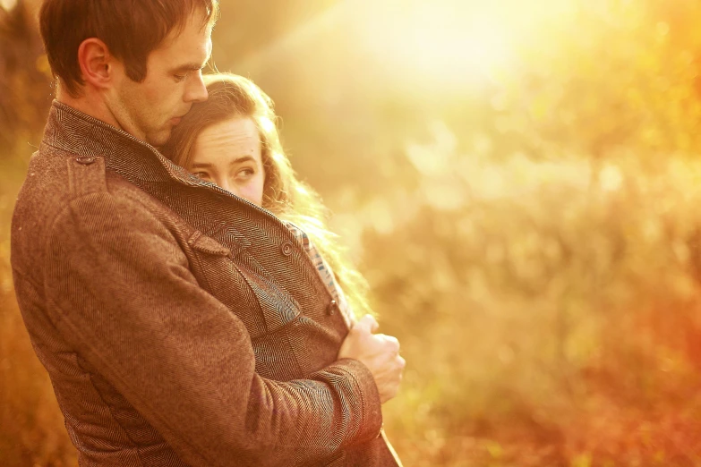 a couple standing together with the sun shining down on them