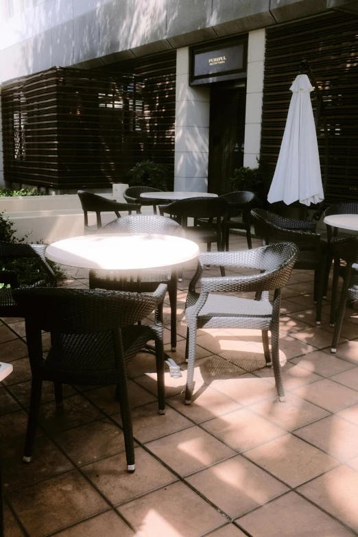the patio area has white umbrellas and dark chairs