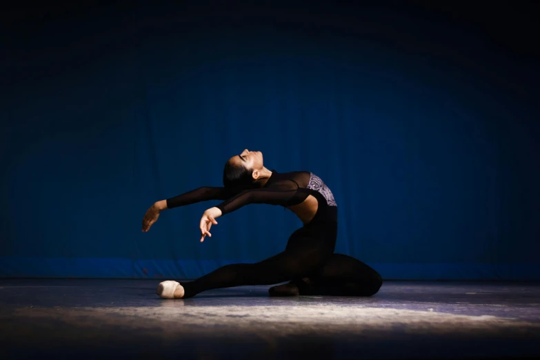 an african american dancer poses with her  and arms extended