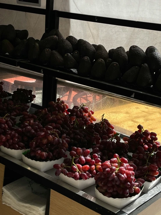 fresh fruits in bowls lined up and placed on a glass display