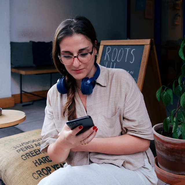 a person that is sitting on a couch with a cell phone