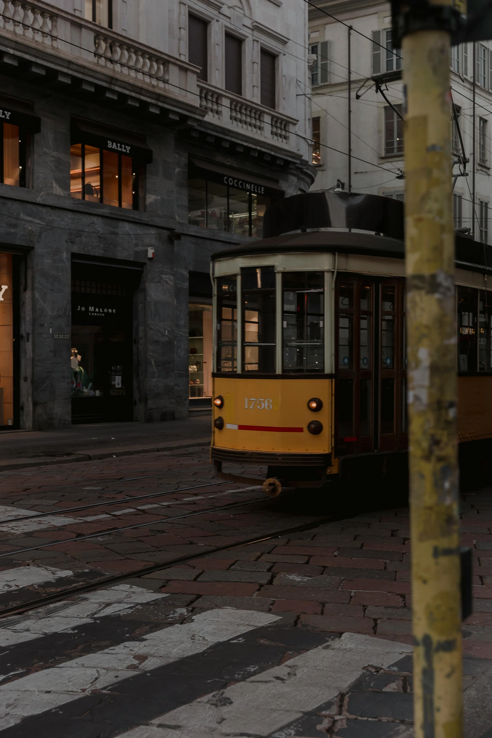 old trams and trolley cars pass each other in a city