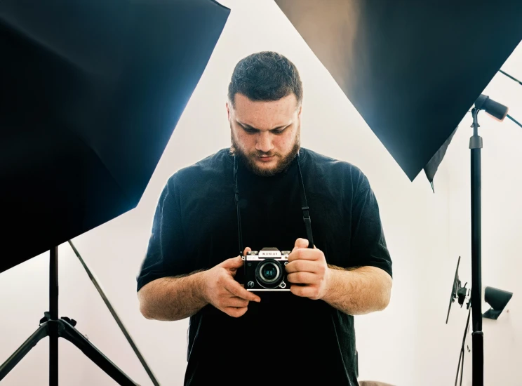 a man in front of many lights taking a po