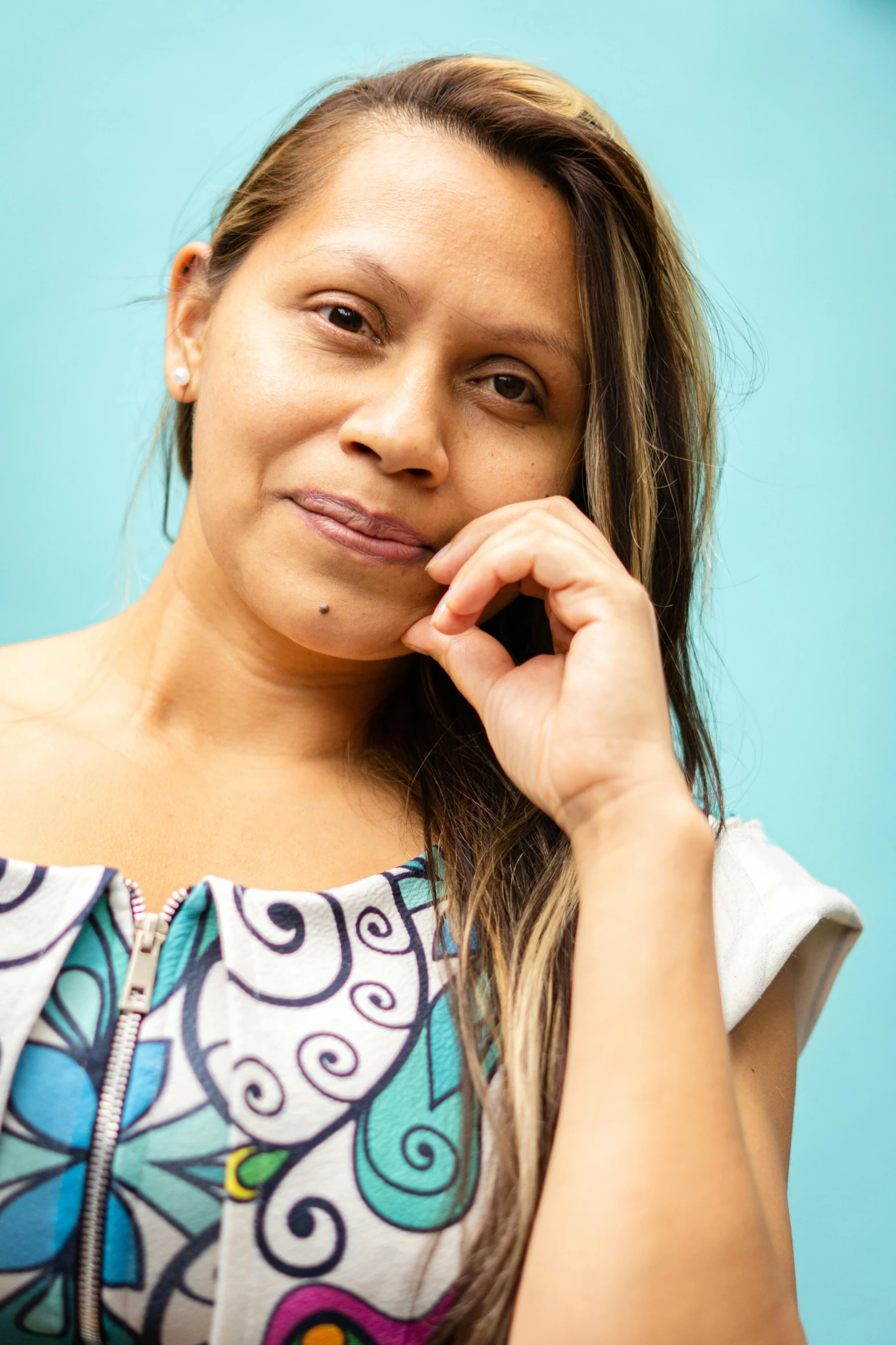 a woman posing in front of a blue wall