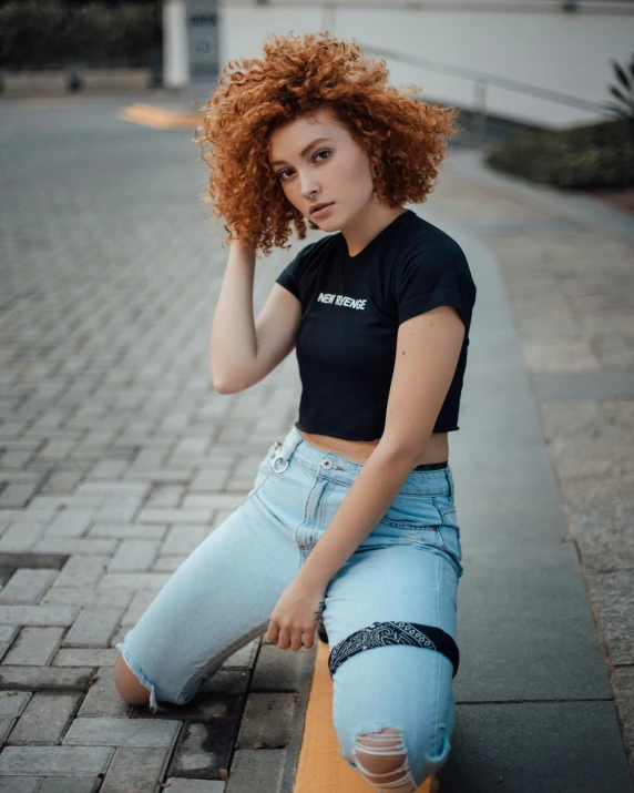 a woman sitting on a bench posing for the camera