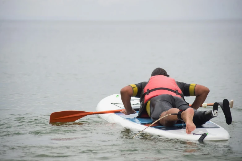 a man on top of a board while laying on top