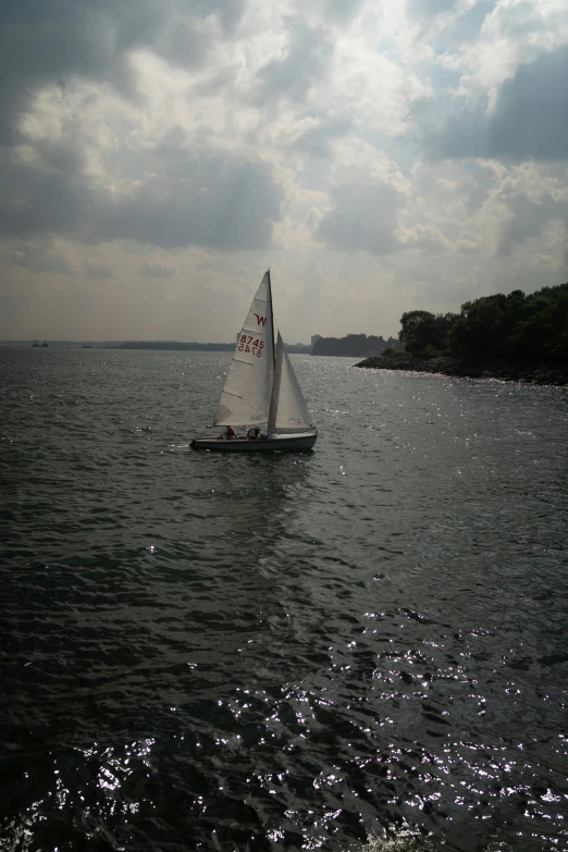 a sailboat with white sails glides through the water