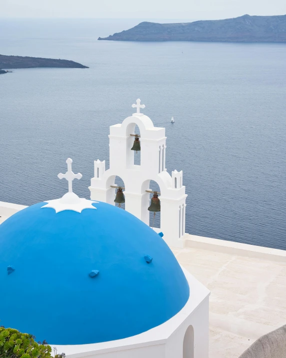 this is the dome of an old greek church near a body of water