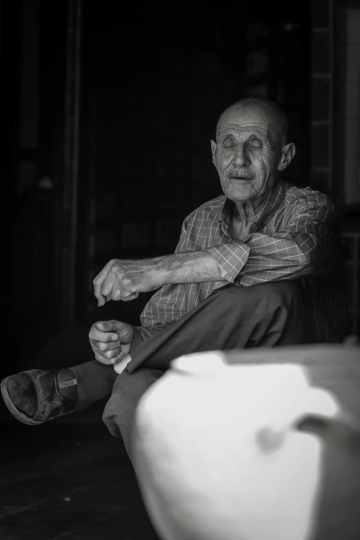 an older man sitting on a chair with his feet up