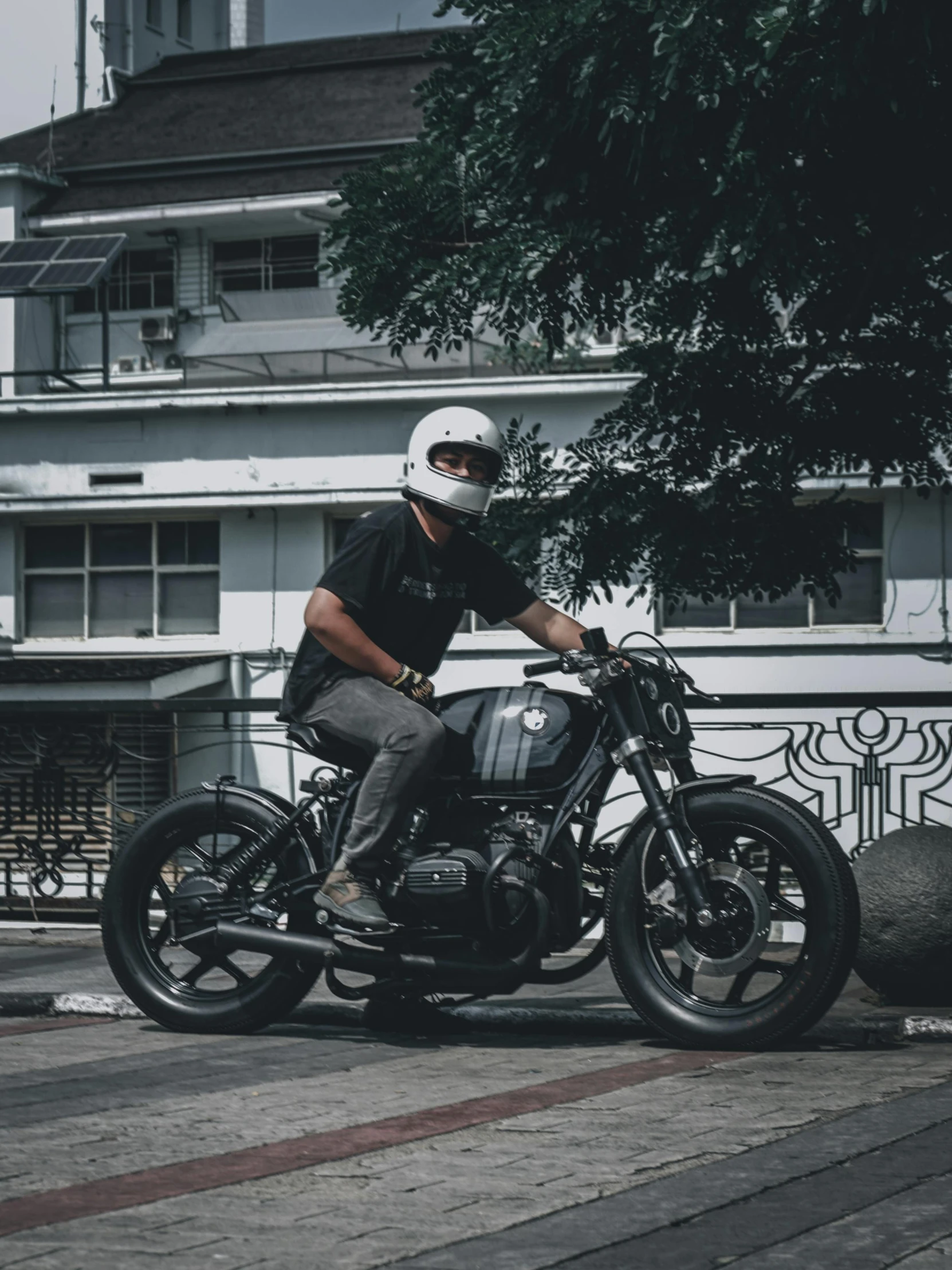 a man riding a motorcycle on the sidewalk