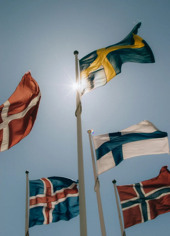 the sun shines through the sky behind several flags