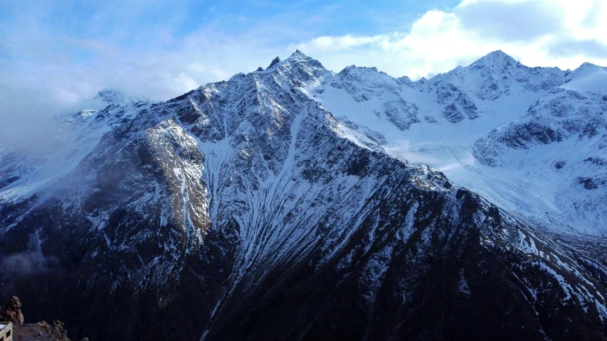 the large snow covered mountain has very steep sides