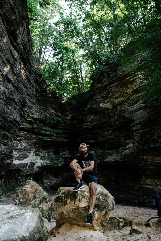 a man sitting on top of a large rock