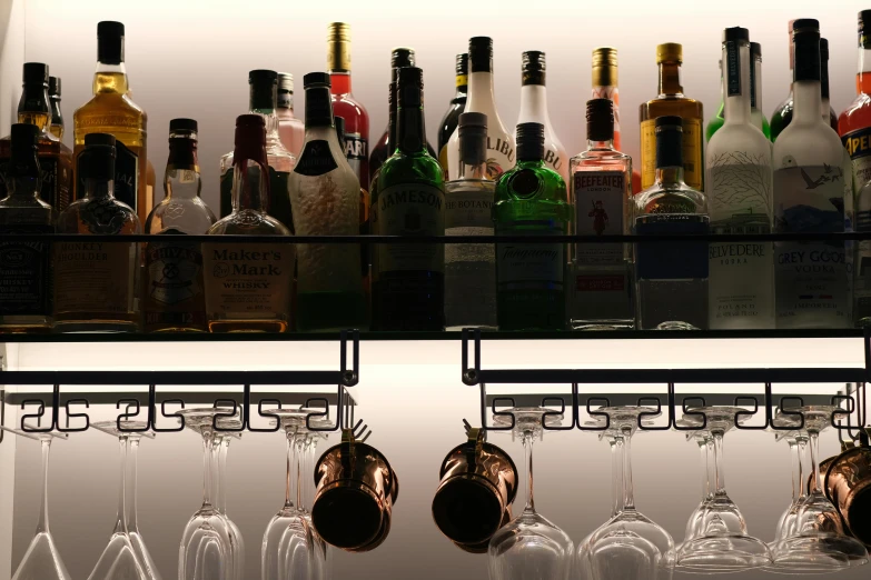 bottles, glasses and decantes lined up behind bar