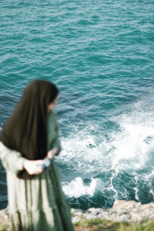 a woman in long dress looking at water