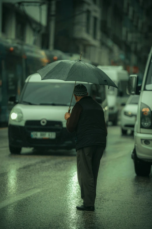 a man walks down a street in the rain with an umbrella