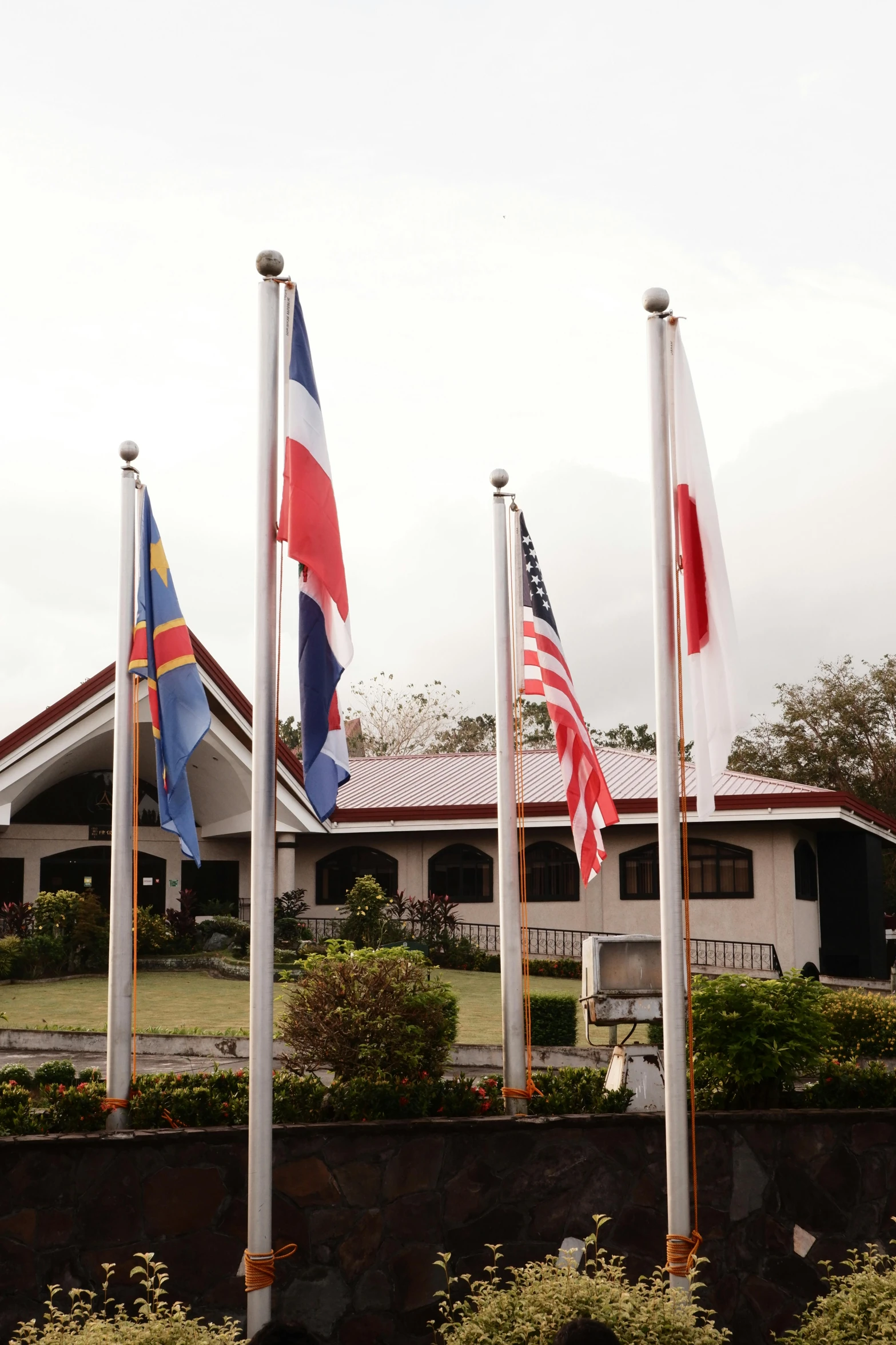 various flags are flying near the building and stone walls