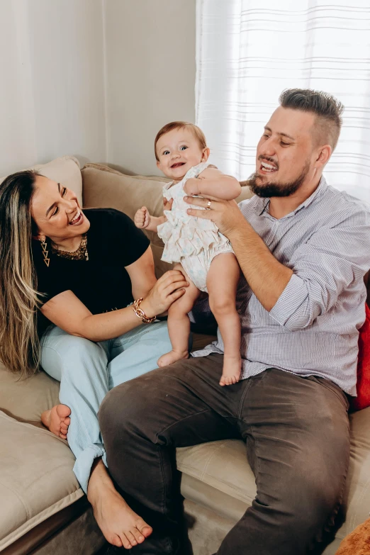 the couple holding their baby girl, who is being held by her father