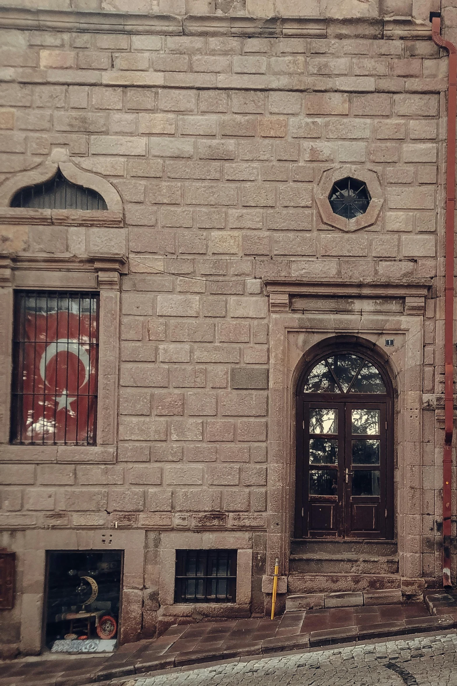 a brick building has a red flag near the doorway