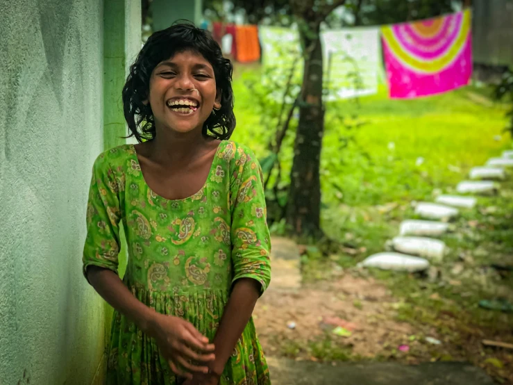 a little girl in a green dress posing