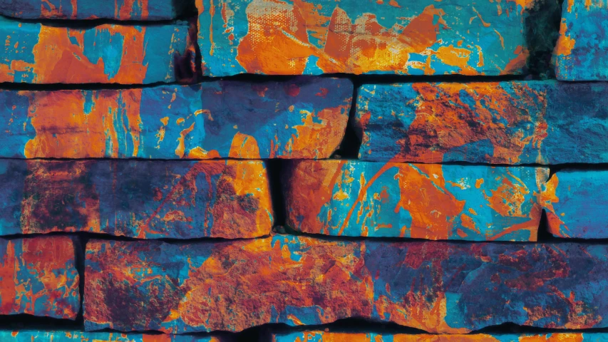 the back wall of an old brick wall painted with blue, orange and yellow paint