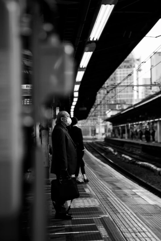 people waiting on the platform at a train station