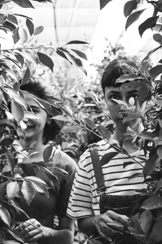 two people painted with paint standing among plants