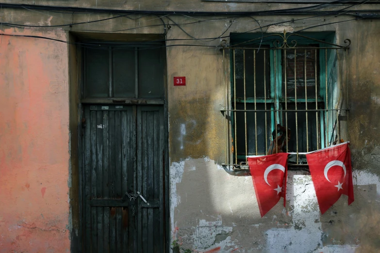 two turkey flags are hanging in front of a barred window