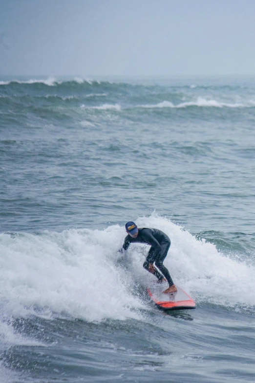 a person in wetsuit surfing on the ocean waves