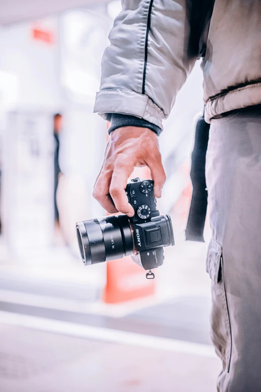 a person holding onto a black camera as they walk