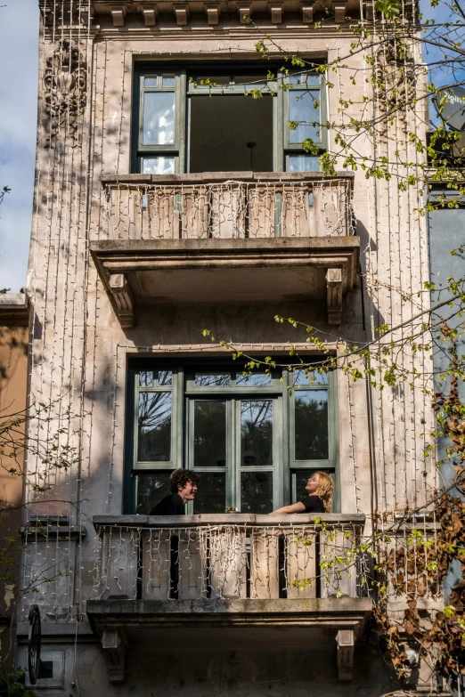 two people sitting in the upper level balcony of a building