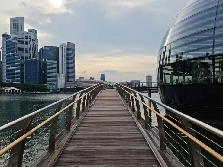 a bridge going to the ocean with city in background