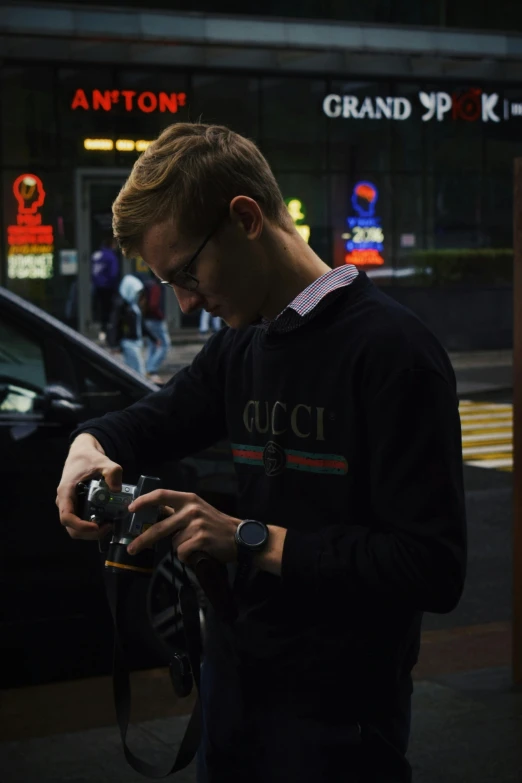 a man standing in front of a car using a phone