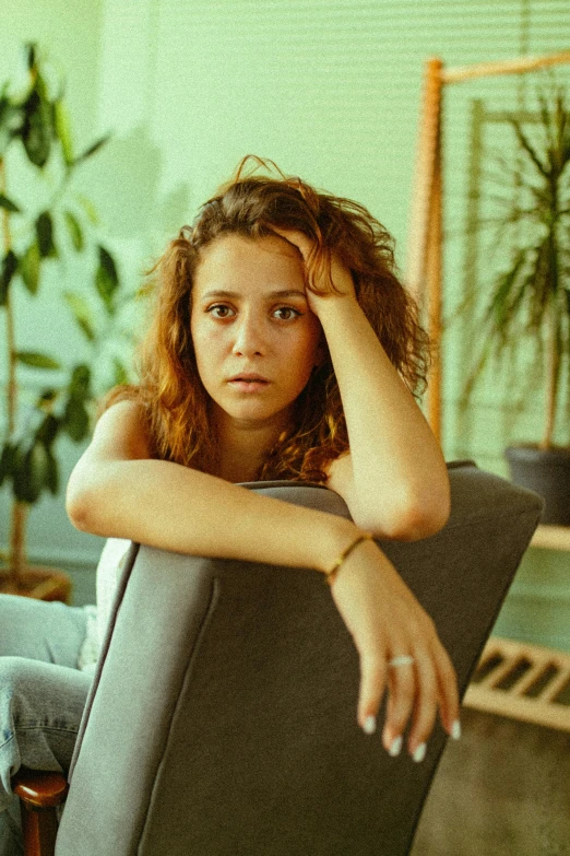 a woman sitting on top of a chair next to a table