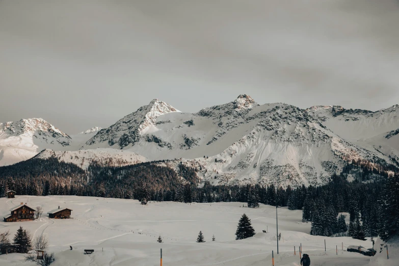 a very snowy mountain with some snow covered mountains in the background