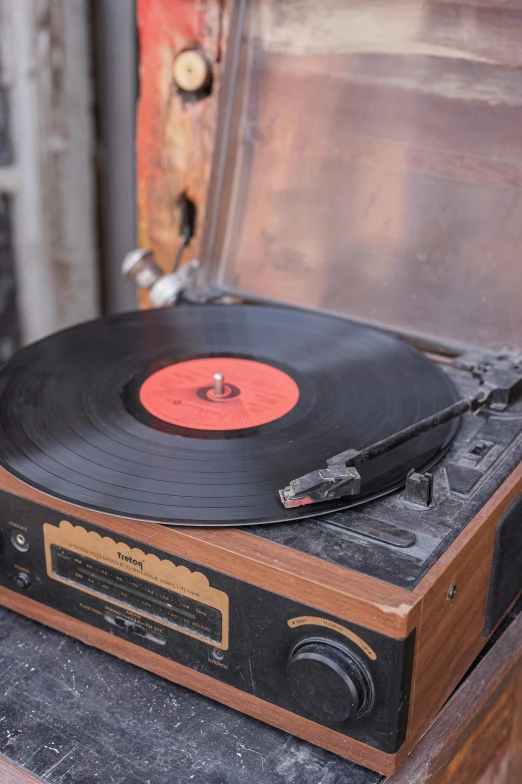 a record player with a wood case and cover sitting on top of a cabinet