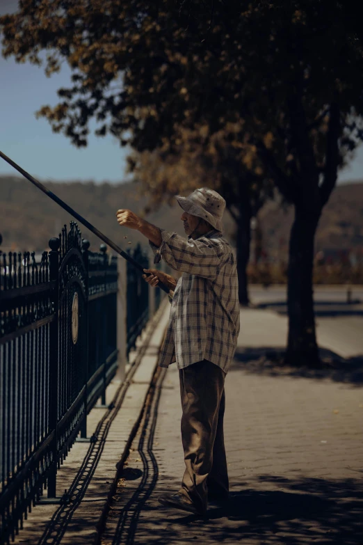 man standing by the fence, feeding a bird