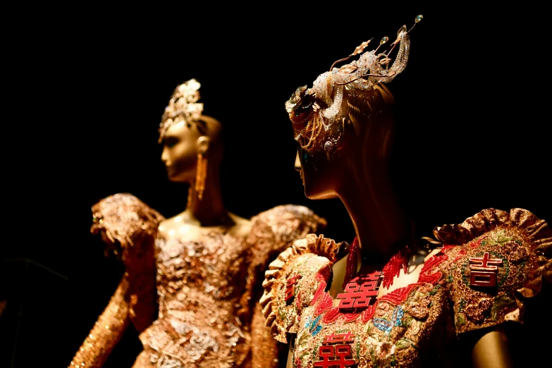 three mannequins dressed in different colored fabrics