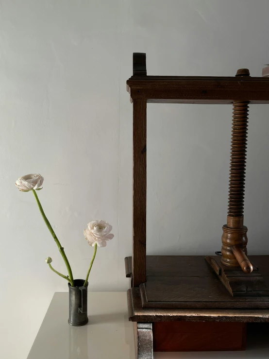 a flower in a small vase next to a large machine