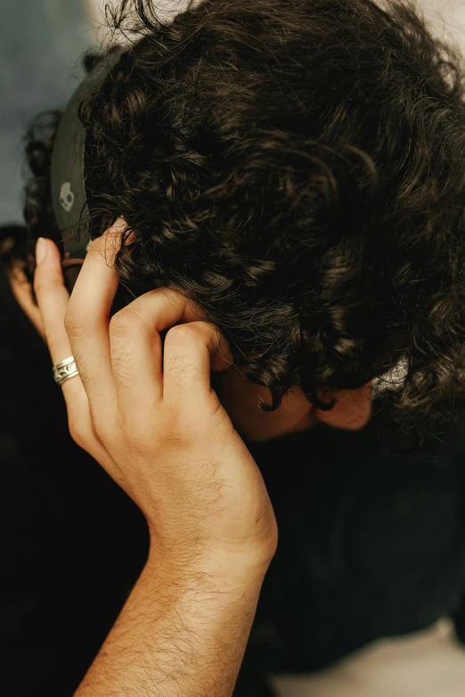 a young person holding up their hair to their face